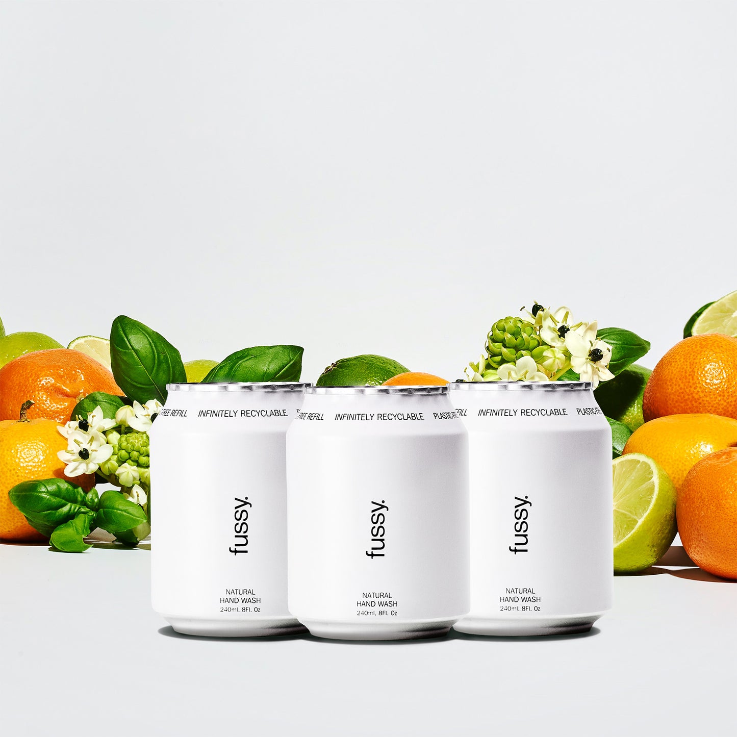 Fussy's Tropic Tonic Refill Pack for hand wash featuring three refills set against a backdrop of limes, basil leaves and mandarins.